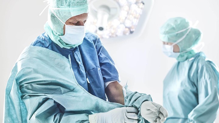 Ķirurgs ietērpjas halātā pirms operācijas